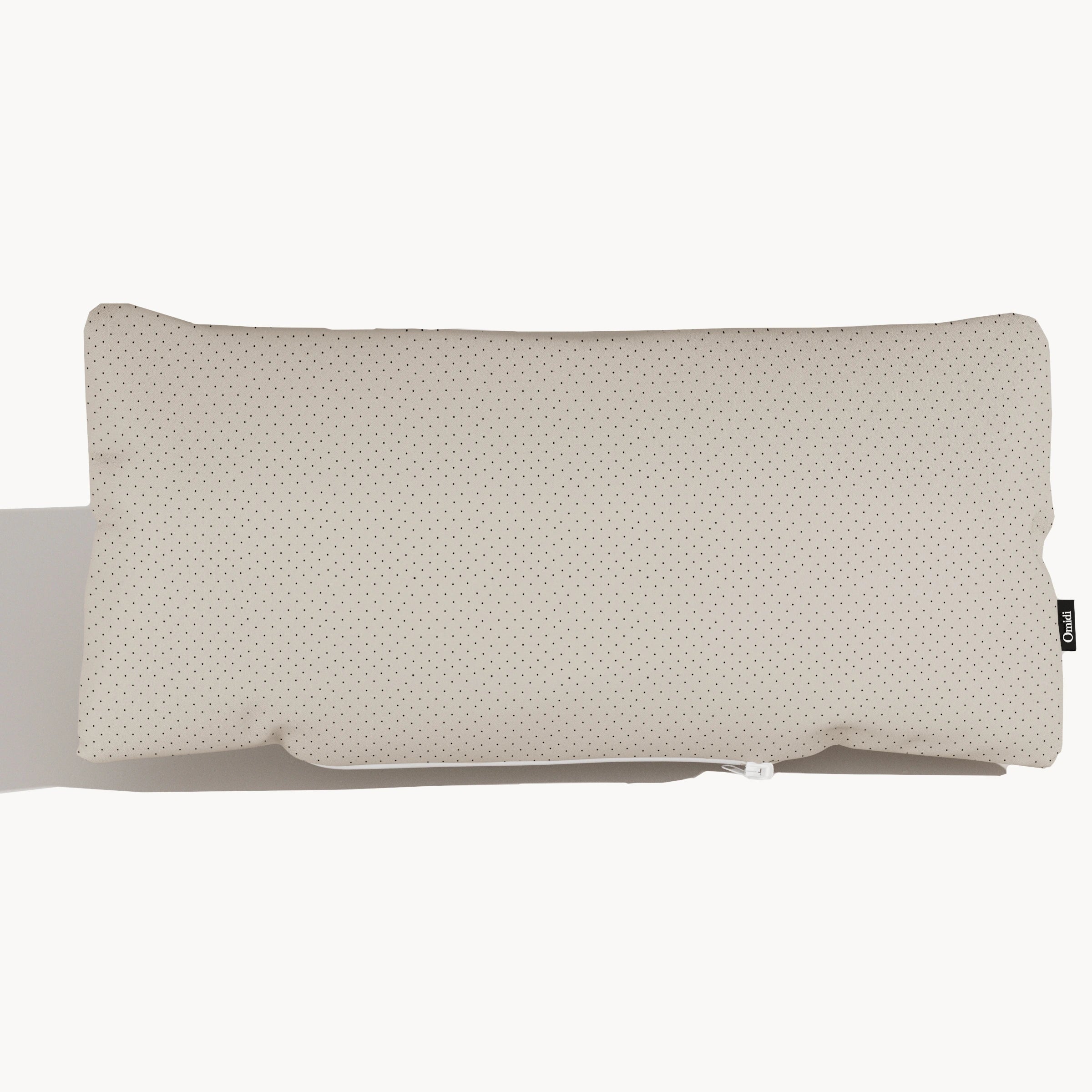 Light beige full-grain leather cushion with dotted texture and side tag