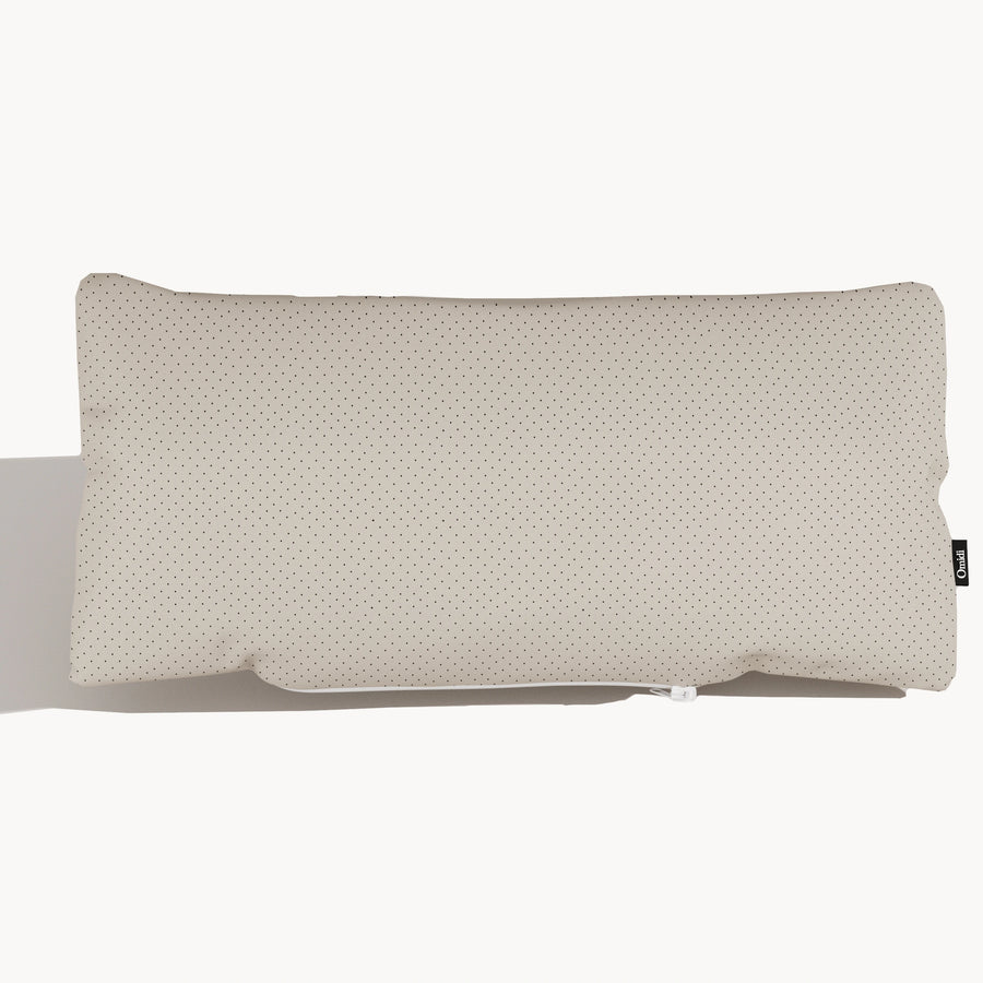 Light beige full-grain leather cushion with dotted texture and side tag